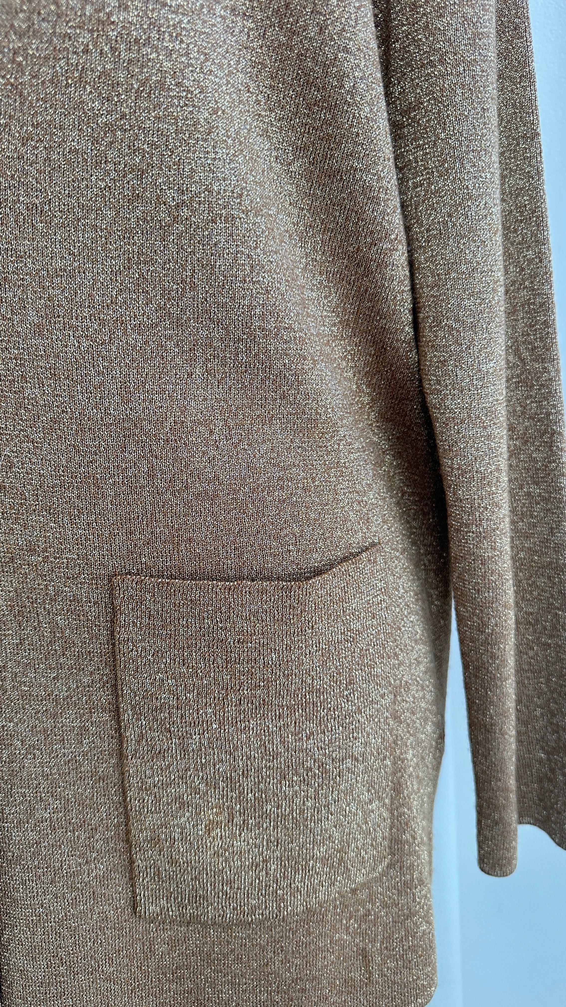 Close-up of a brown textured sweater with a pocket on a light blue background