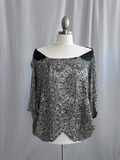 Black and white patterned blouse on a mannequin against a plain background