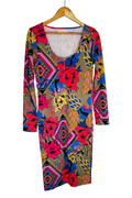 Long-sleeve dress on a wooden hanger, front view. Scoop neckline with a short silver center-front zip. Mixed print of geometric diamond medallions and oversized florals in red, pink, gold, and blue over an olive ground.