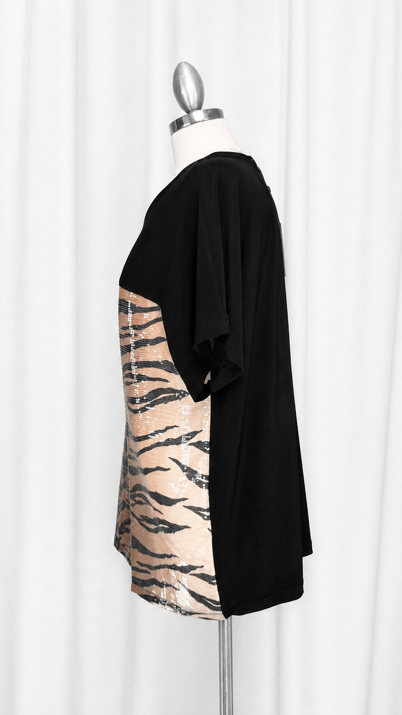A black short-sleeve tunic top with a beige tiger-stripe pattern panel, displayed on a mannequin against a white curtain background.