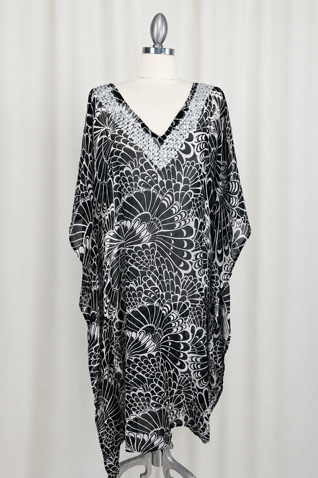 Black and white patterned dress on a mannequin against a white background