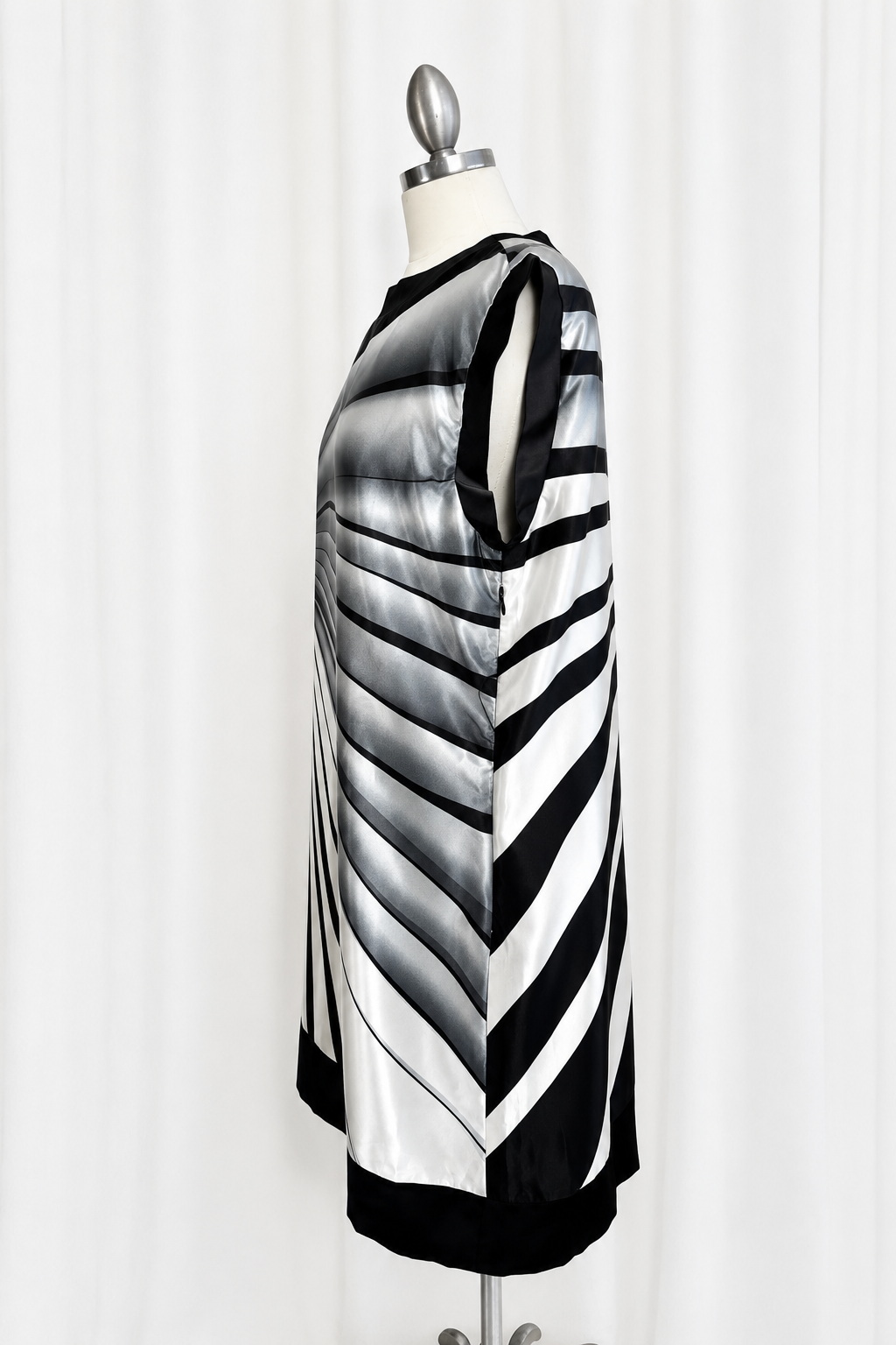 Black and white striped dress on a mannequin against a white background