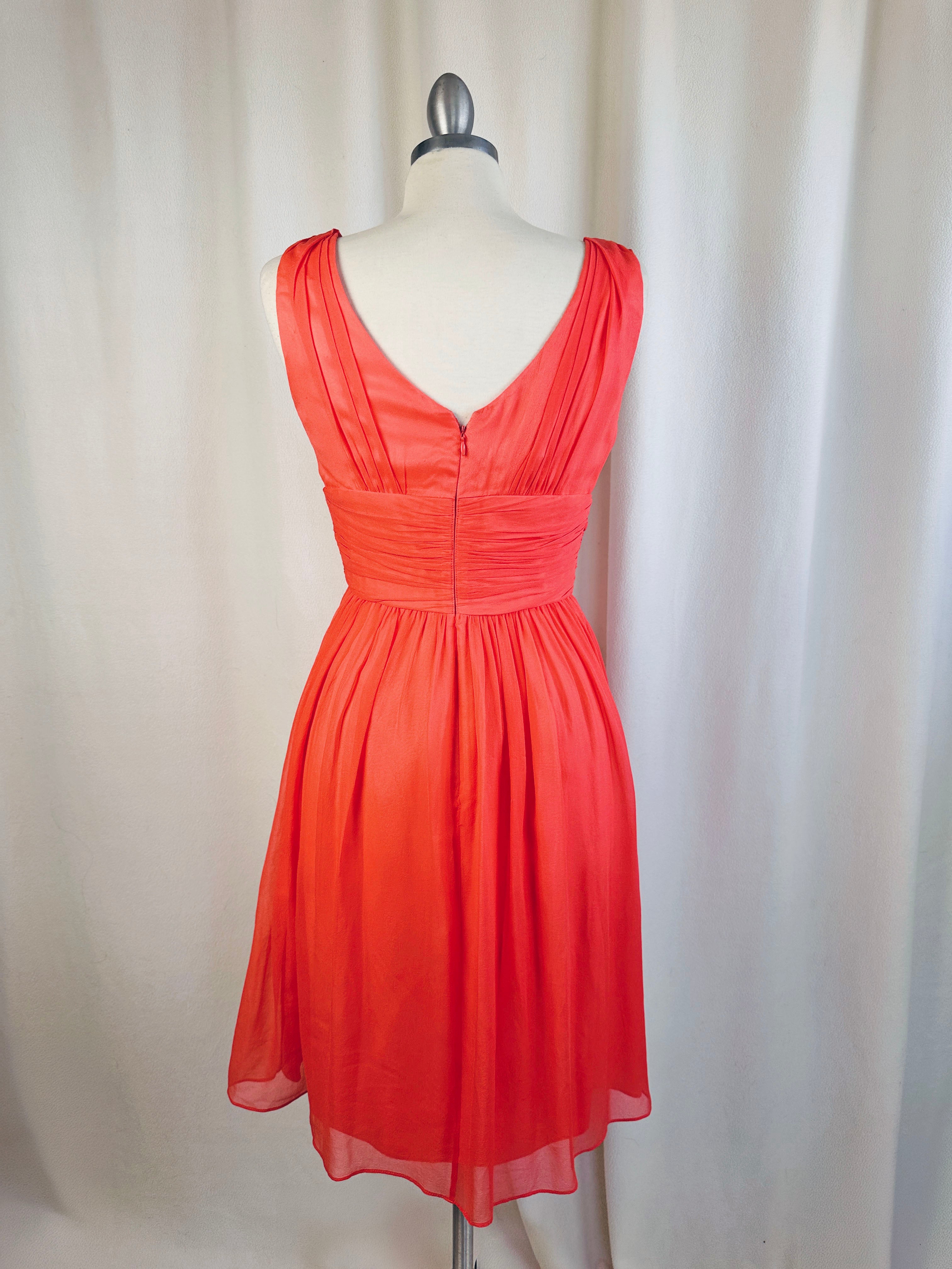 Coral dress on a mannequin against a white background