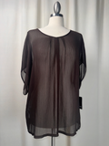 Black sheer blouse on a mannequin against a white background