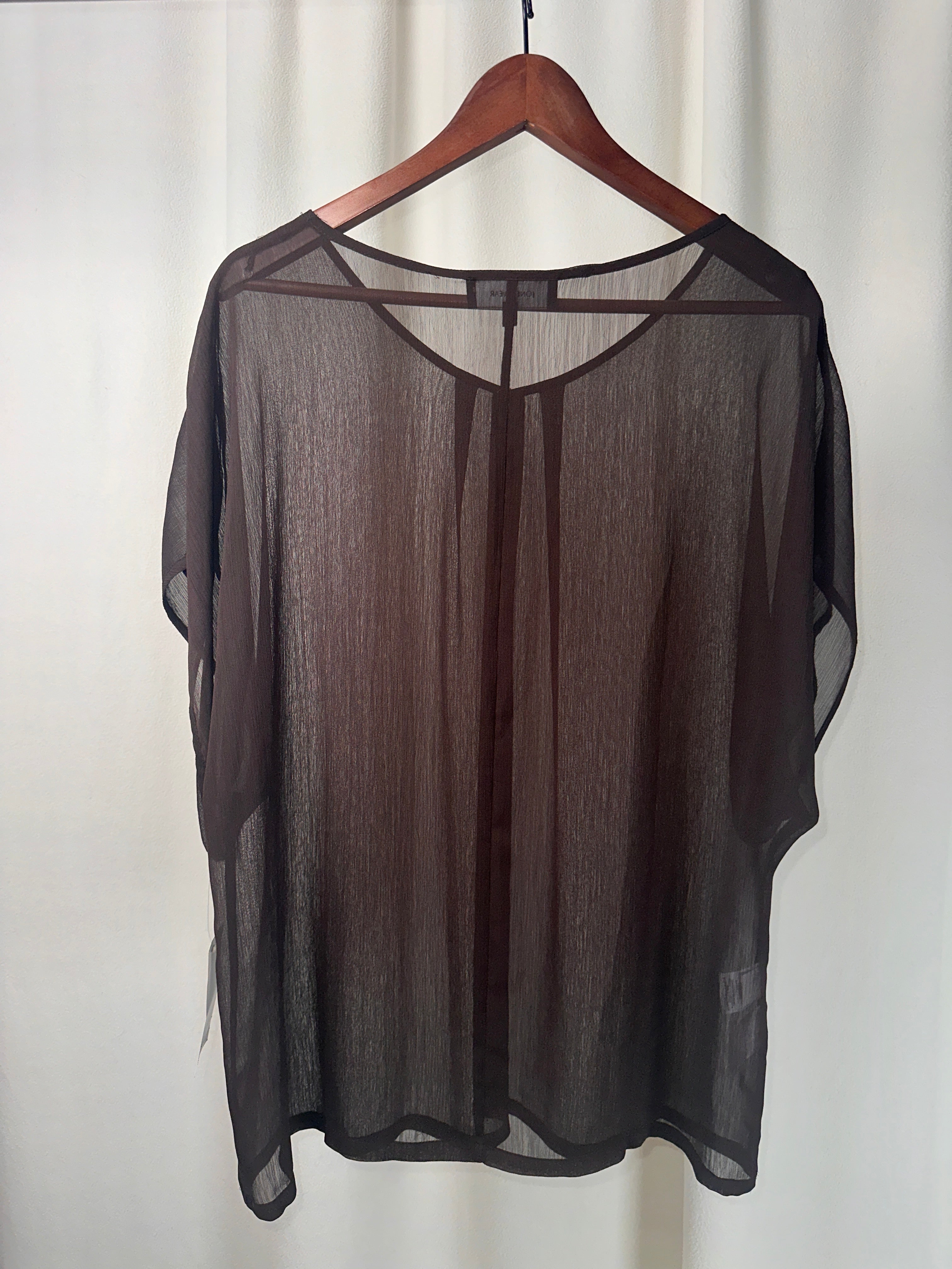 Black sheer blouse on a mannequin against a white background