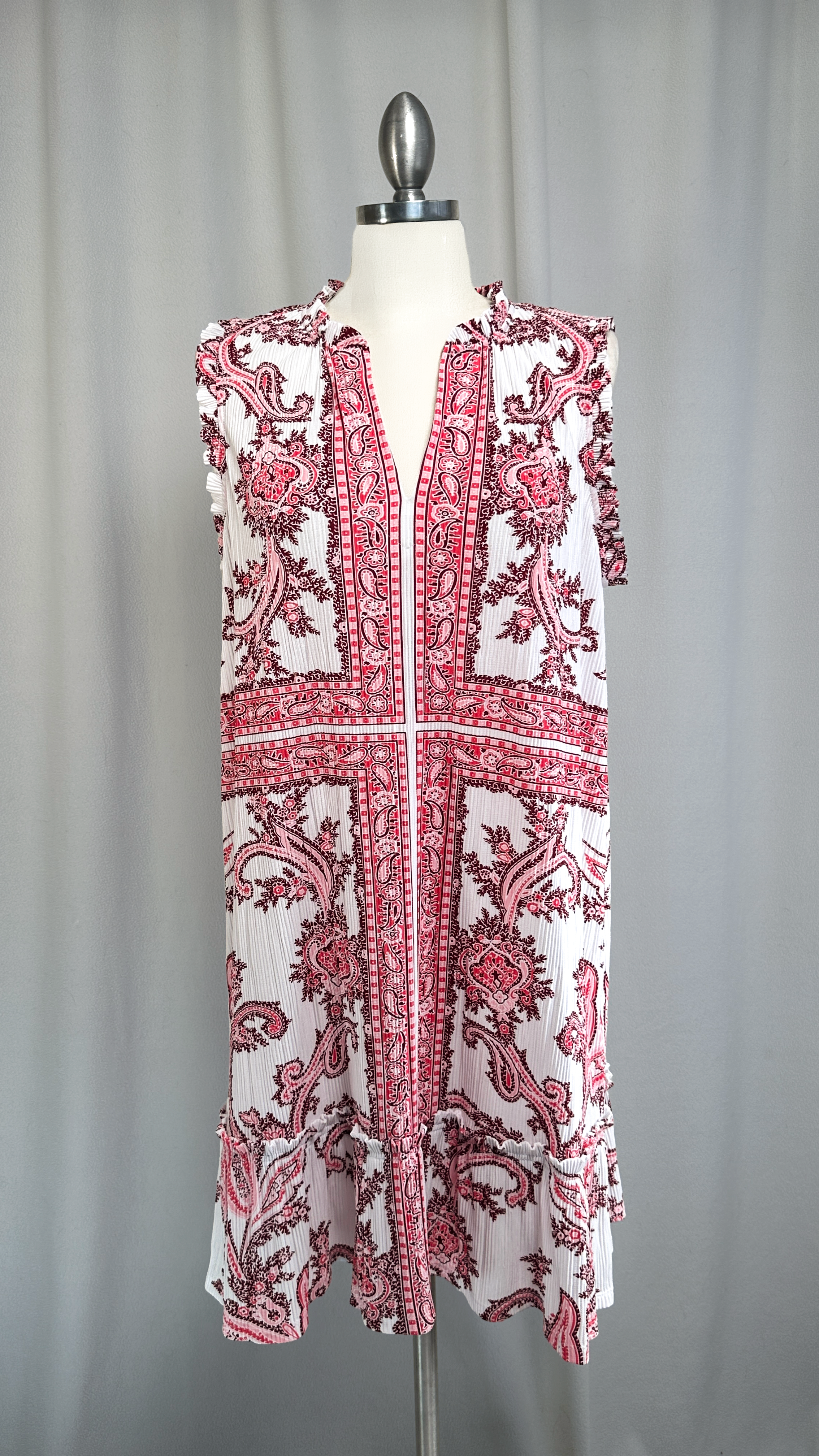 Red and white patterned dress on a mannequin against a gray background