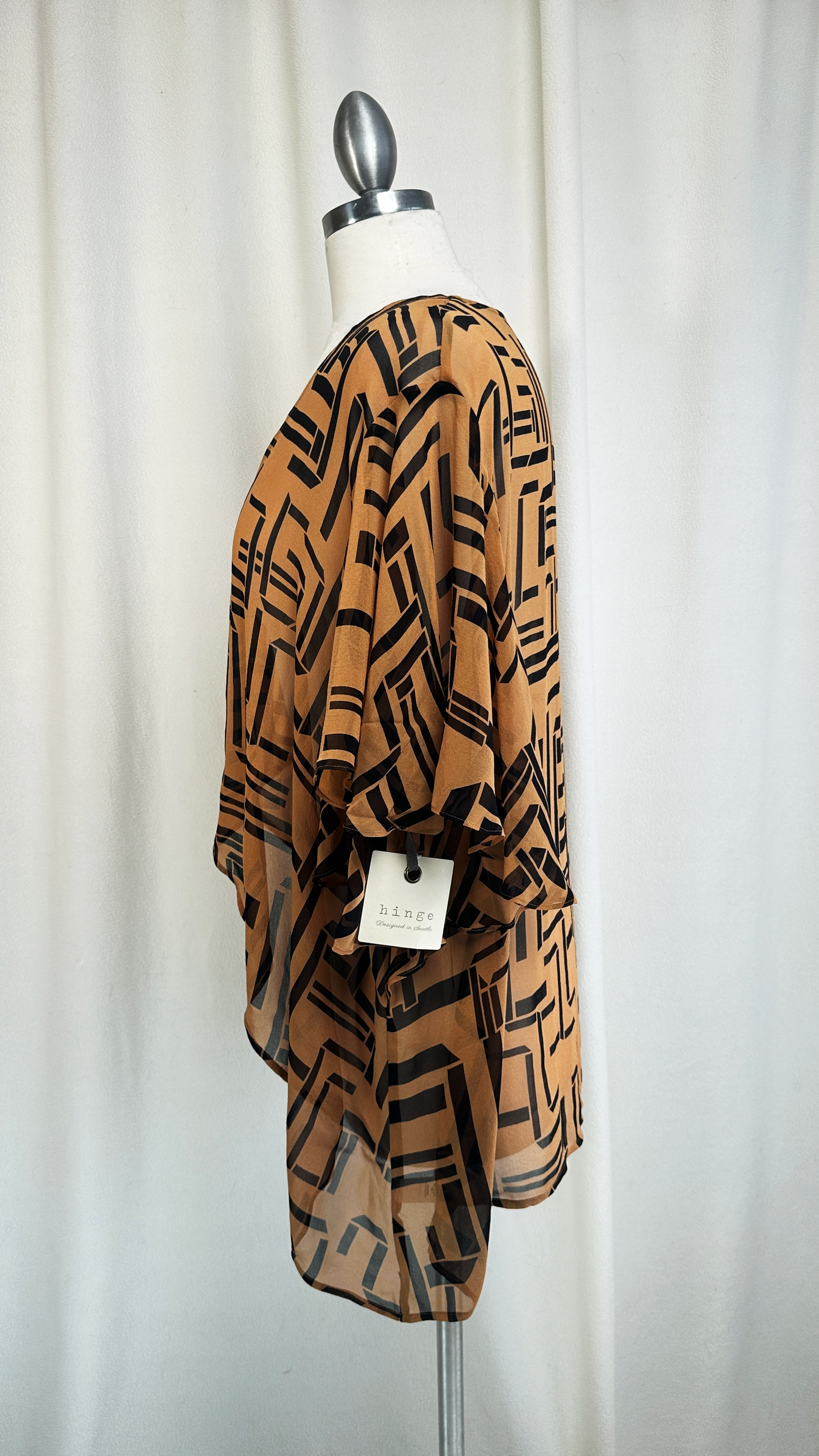Brown patterned dress on a mannequin against a white background. Side view.