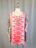 Colorful patterned top on a mannequin against a plain background