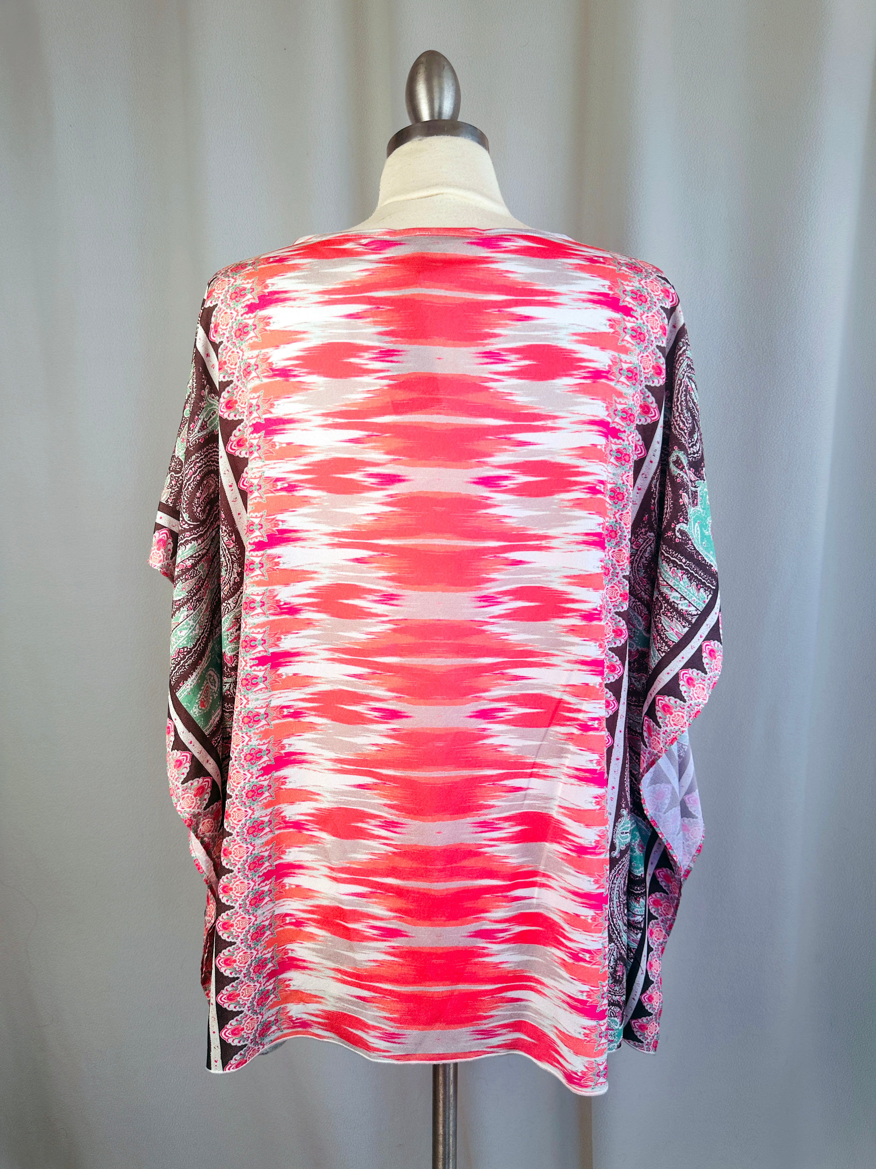 Colorful patterned shirt on a mannequin against a plain background