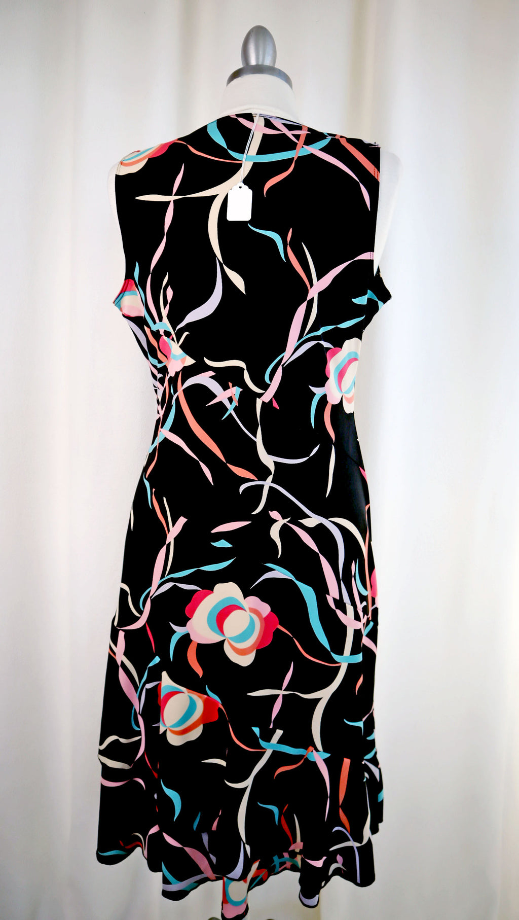 Black sleeveless dress with colorful floral pattern on a white background
