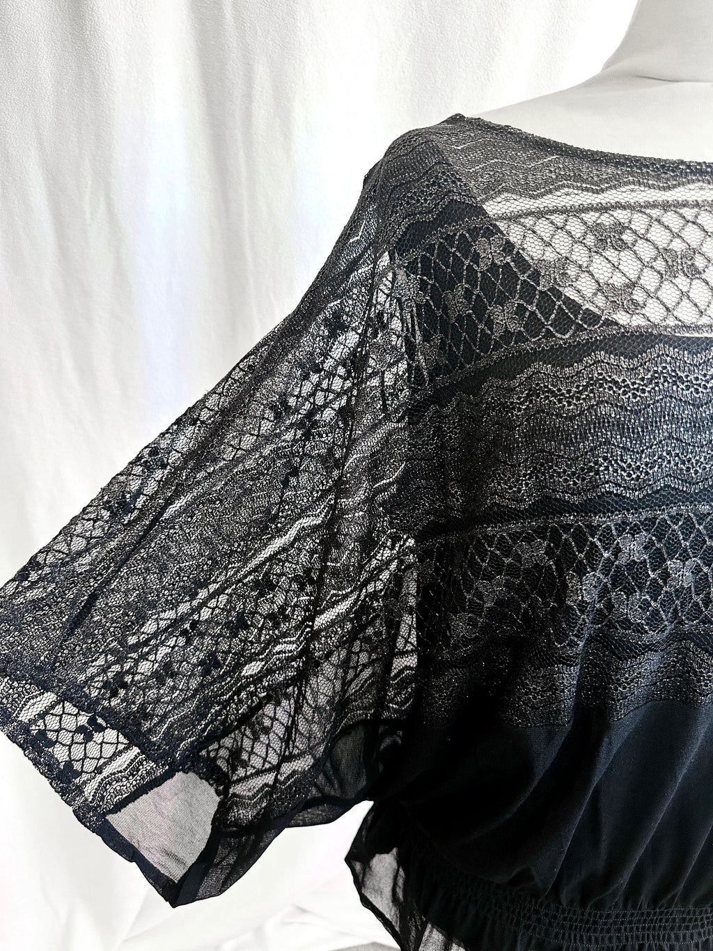 Black lace garment on a mannequin against a white background