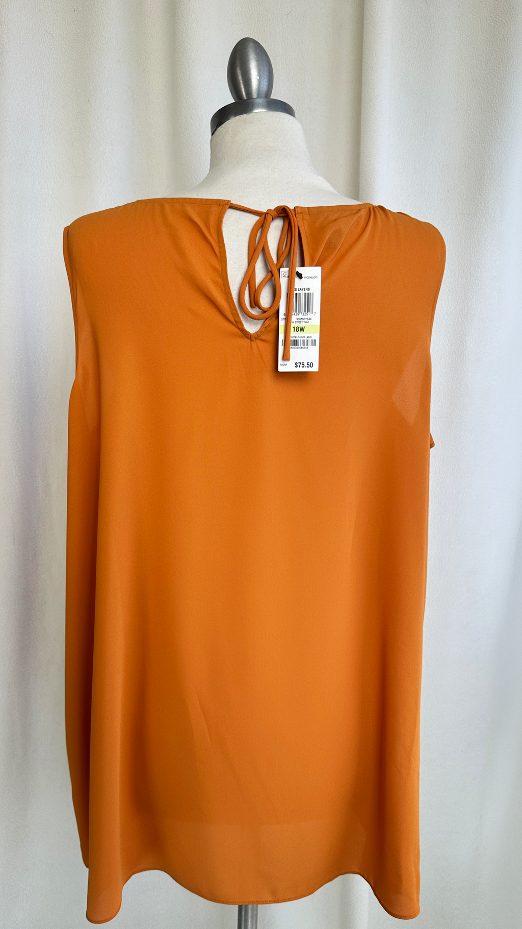 Orange sleeveless top on a mannequin with a white background